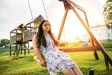 A Portrait of trisomie 21 adult girl outside at sunset
