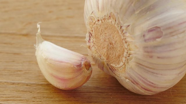 Close up of garlic bulb and clove on wooden rustic board. Healthy eating, aromatic spice.