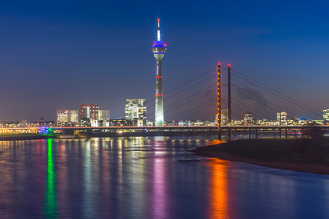 Fototapeta na wymiar Rheinkniebrücke (Bridge) and Rheintrum TV Tower at the river Rhine during blue hour 