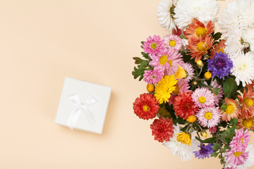 Top view of big bouquet of colorful different flowers and a gift box..