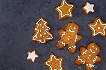 Christmas cookies - star, tree shapes, gingerbread man, white glaze on gray concrete background. Recipe, invitation concept. Top view, flat lay, close-up, copy space, layout design