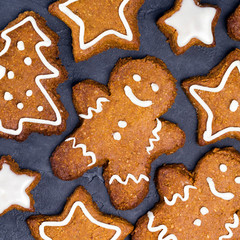 Christmas cookies - star, tree shapes, gingerbread man with white glaze on gray concrete background. Recipe, invitation concept. Top view, flat lay, close-up, square layout design