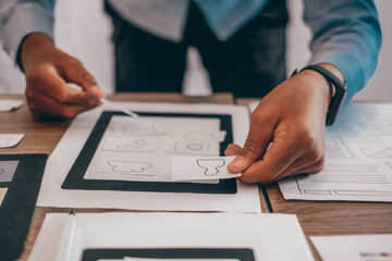 user experience UX designer designing web on smart phone layout. UI developer planning working on...