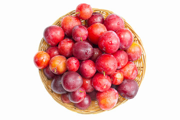 Plums in the basket top view on a white background