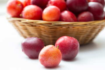 Plums closeup on a background of a basket of fruit.