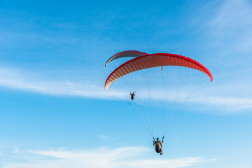 Paragliding Extreme sport, Paraglider flying on the blue sky and white cloud in Summer day at Phuket Sea, Thailand.