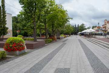 A beautiful european new street city park with bright blooming flower beds, beautiful street lanterns and beautiful sidewalks.
