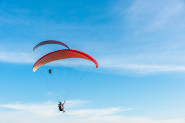 Paragliding Extreme sport, Paraglider flying on the blue sky and white cloud in Summer day at Phuket Sea, Thailand.