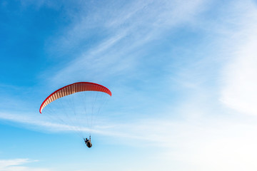 Paragliding Extreme sport, Paraglider flying on the blue sky and white cloud in Summer day at Phuket Sea, Thailand.