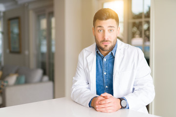 Fototapeta premium Young handsome doctor man at the clinic depressed and worry for distress, crying angry and afraid. Sad expression.