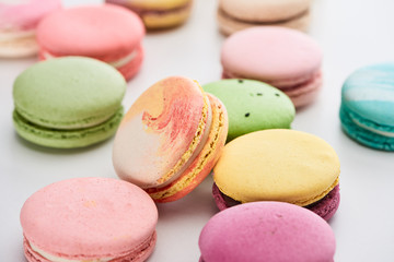 Fototapeta na wymiar close up view of sweet colorful French macaroons of different flavors on white background, panoramic shot
