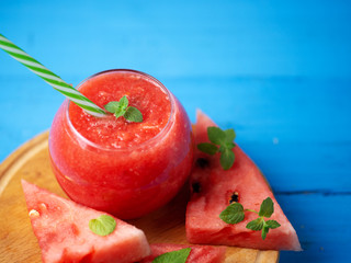 Fresh watermelon smoothie on wooden blue background .