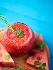 Fresh watermelon smoothie on wooden blue background .