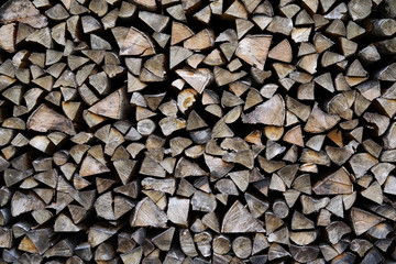 A pile of stacked firewood, prepared for heating the house. Firewood harvested for heating in winter