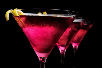 Cropped three cosmopolitan cocktails in line on black background