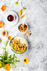 Obraz na płótnie Canvas Bowl of fresh oatmeal porridge with kiwi, peach and granola