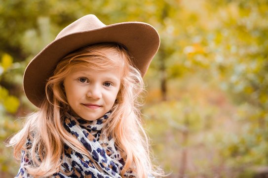 little child  with long blond hair and hat