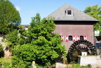 Brüggen, Germany - August 8. 2019: View on medieval watermill with paddle wheel in small german village