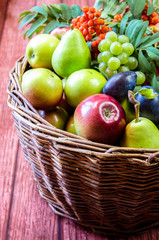 group of healthy autumnal colorful fruits  in wooden basket