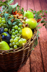 group of healthy autumnal colorful fruits  in wooden basket