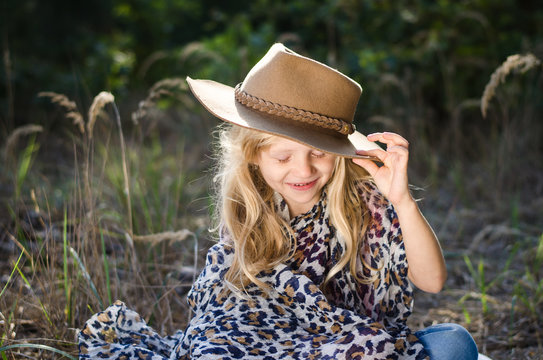 little child  with long blond hair and hat