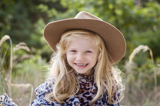 little child  with long blond hair and hat
