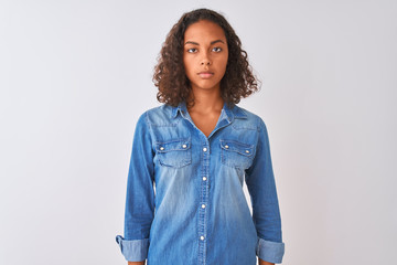 Young brazilian woman wearing denim shirt standing over isolated white background Relaxed with...