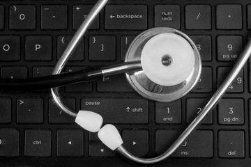 A stethoscope lying on a computer keyboard