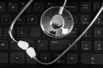 A stethoscope lying on a computer keyboard