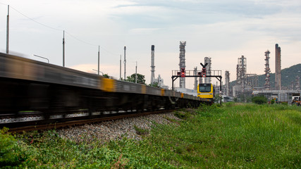 oil and gas refinery plant storage area with train moving foreground and evening in Thailand