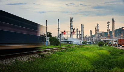 Obraz premium oil and gas refinery plant storage area with train moving foreground and evening in Thailand