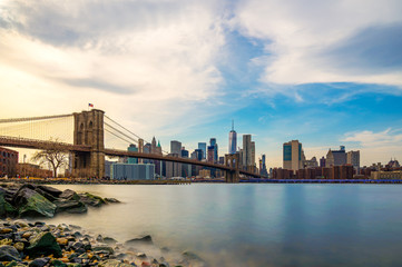 Beautiful sence of Brooklyn bridge and lower manhattan of New York city in dusk evening. Downtown of lower Manhattan of New York city and Smooth Hudson river with sunset light.