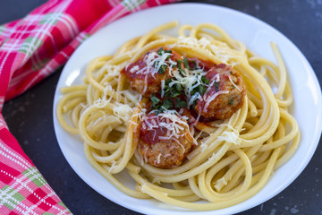 Spaghetti with meatballs and tomato sauce in red plate