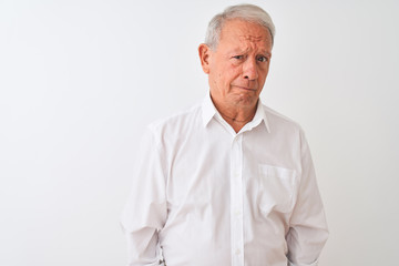 Senior grey-haired man wearing elegant shirt standing over isolated white background depressed and worry for distress, crying angry and afraid. Sad expression.