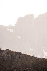 a silhouette of a man in the mountains at the sunset