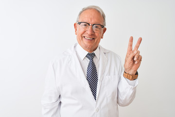 Senior grey-haired scientist man wearing coat standing over isolated white background smiling with...