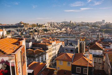 Fototapeta na wymiar 10/22/2019 - Porto, Portugal: Porto panoramic landmark with boats river Douro. Old buildings with brick roofs by river Douro in Porto, Portugal. Historic district of Porto. 