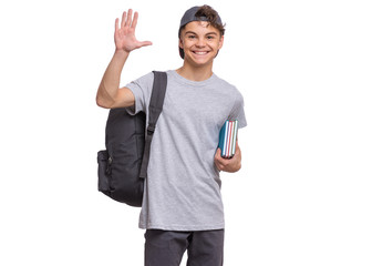 Happy teen boy in cap with books and backpack, isolated on white background. Smiling child making...