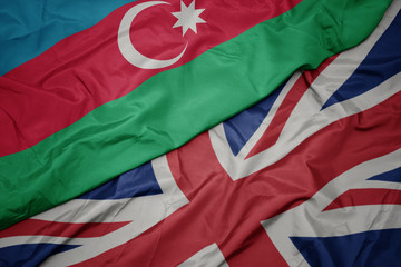 waving colorful flag of great britain and national flag of azerbaijan.