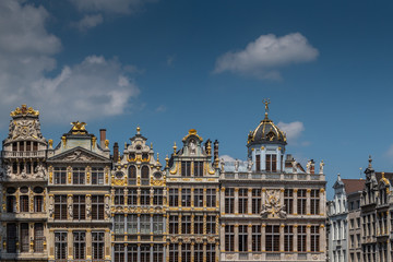 Fototapeta na wymiar Brussels, Belgium - June 22, 2019: Beige stone facades and gables with statues on top at northwest side of grand Place. 