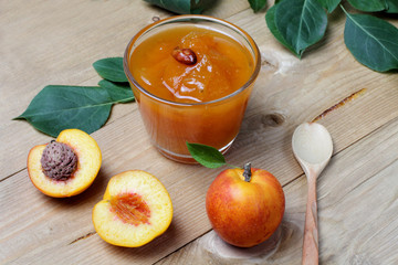Fruits of nectarines or apricots with jam on a table made of dark wood, bright natural colors, high...