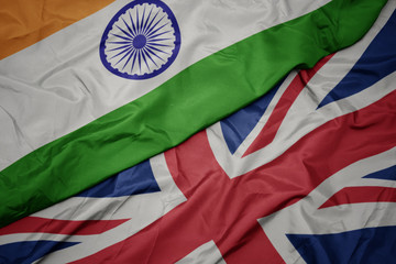 waving colorful flag of great britain and national flag of india.