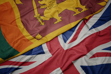 waving colorful flag of great britain and national flag of sri lanka.