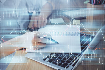 Financial charts displayed on woman's hand taking notes background. Concept of research. Double exposure
