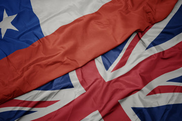 waving colorful flag of great britain and national flag of chile.