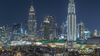 Fototapeta na wymiar Aerial nighttime cityscape with illuminated architecture of Dubai downtown timelapse, United Arab Emirates.