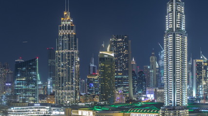 Fototapeta na wymiar Aerial nighttime cityscape with illuminated architecture of Dubai downtown timelapse, United Arab Emirates.