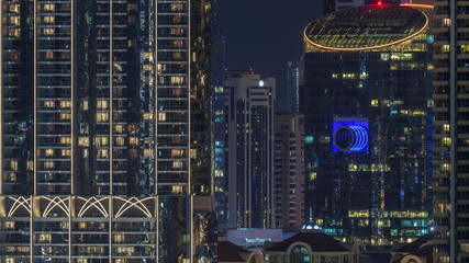 Aerial nighttime cityscape with illuminated architecture of Dubai downtown timelapse, United Arab Emirates.