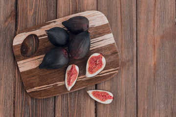 Fresh ripe figs on the brown wooden background.