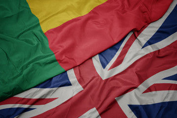 waving colorful flag of great britain and national flag of benin.